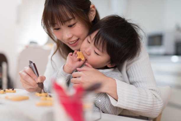 母亲和孩子在厨房里一起做饼干图片下载