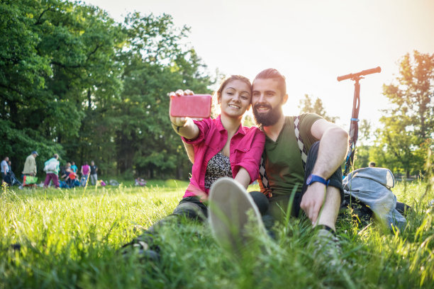 一对青少年情侣在公园里自拍图片下载