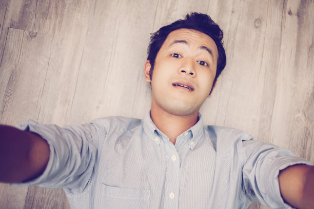一名亚洲男子躺在地上自拍图片下载