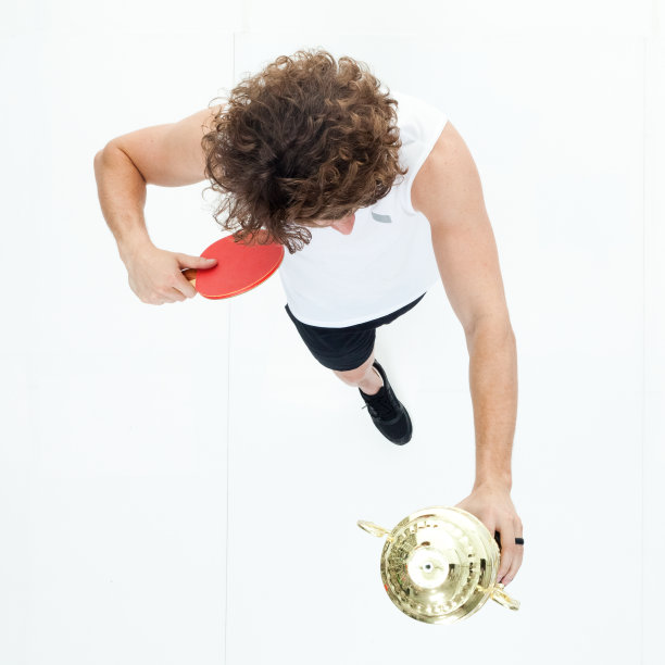 年轻的运动员拿着奖杯和乒乓球拍图片下载