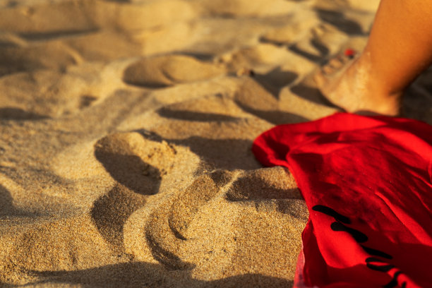 沙滩浴巾，女人的脚，阳光照射。图片下载