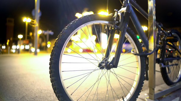 近景自行车停在道路附近，照亮了夜市的背景图片下载