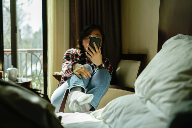 在酒店房间里看手机的女孩图片下载