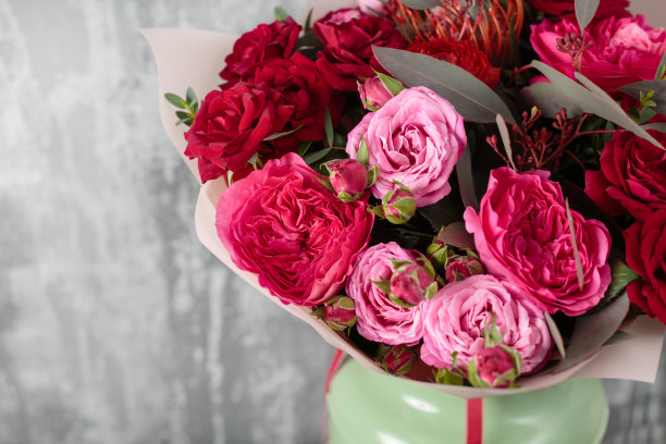 特写美丽的花束。灰色背景上的春花。花店。木制的桌子素材图片