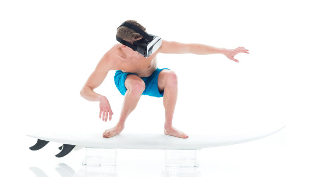 迷人的年轻人冲浪和使用VR耳机图片下载