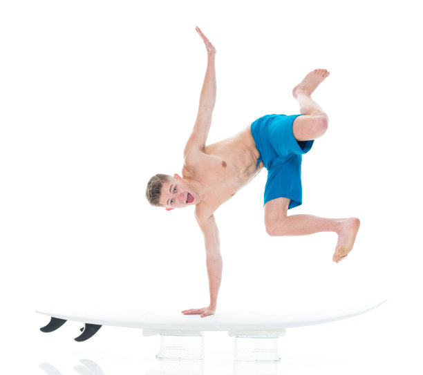 英俊的年轻人冲浪和做倒立图片下载