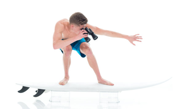 英俊的年轻人冲浪用双筒望远镜图片下载