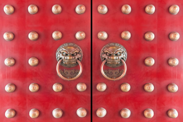 木制的中国门漆成红色，带有中国传统青铜狮头门环。中国寺庙的木门入口图片下载