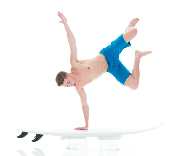 英俊的年轻人冲浪和做倒立图片下载