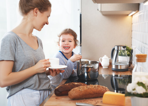 准备家庭早餐。母亲和孩子女儿在早上煮粥图片下载