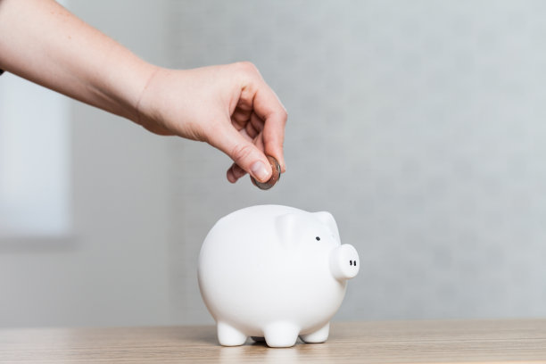 把一枚硬币投进存钱罐图片下载