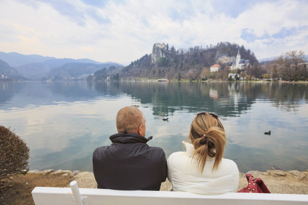 一对相爱的游客。欣赏欧洲斯洛文尼亚布莱德湖的景色。图片下载