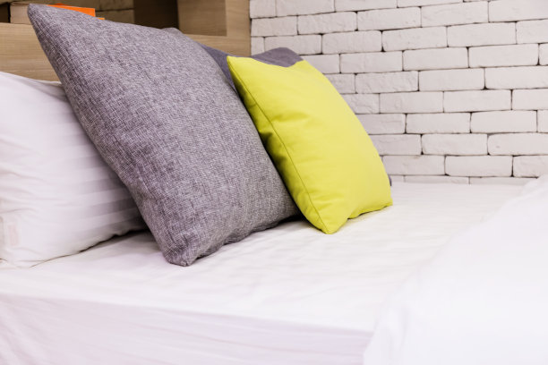 美容室的床上堆满了干净的白色枕头和床单。特写镜头。阳光下的镜头。图片下载