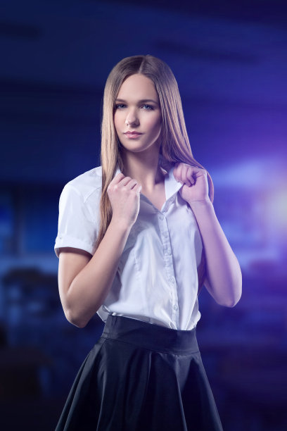漂亮的少年在模糊的学校背景下自信地看着你。这个女孩穿着校服，白衬衫和黑裙子图片下载