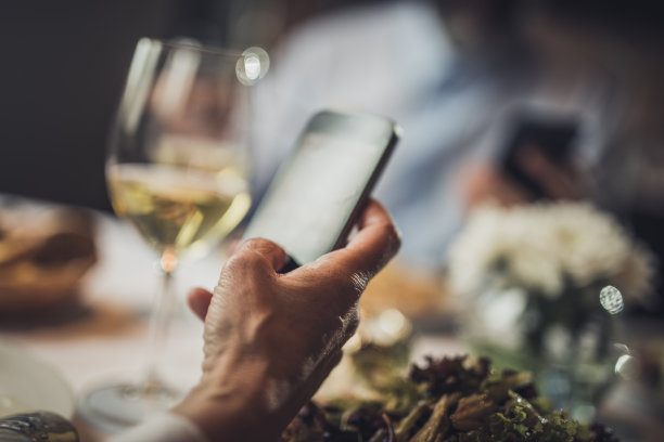 近距离观察一个面目全非的女人在一家餐厅使用手机。图片下载