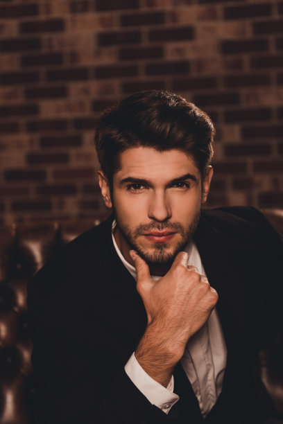 年轻英俊性感的男人抚摸下巴的肖像图片下载