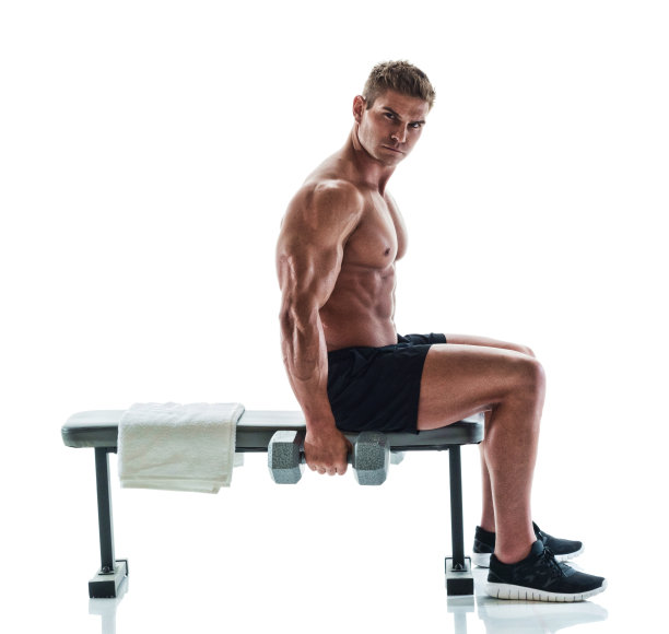 肌肉发达的帅哥在健身长椅上举着哑铃图片下载