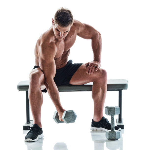 肌肉发达的帅哥在健身长椅上举着哑铃图片下载