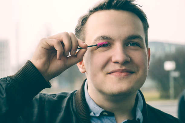 年轻人用粉色的睫毛刷擦脸。图片下载