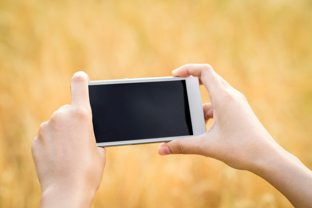 女人在日落户外手握智能手机图片下载