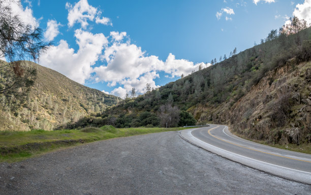 广角图片高速公路弯曲进入山区与蓝天图片下载