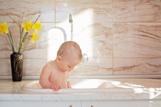 可爱的小男孩，早上在厨房的水槽里洗澡图片下载