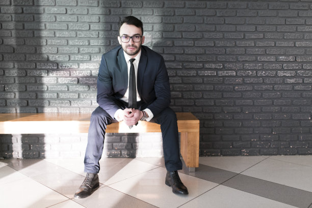 一个商务人士坐在办公室的长凳上图片下载