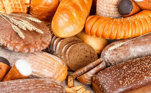 桌上有刚烤好的黑麦面包和小麦面包。整条和切片的面包图片下载