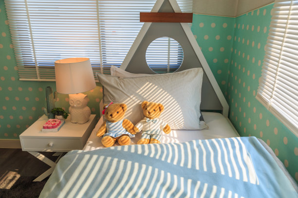 一对棕色的泰迪熊夫妇倚靠在床上的白色枕头上。图片下载