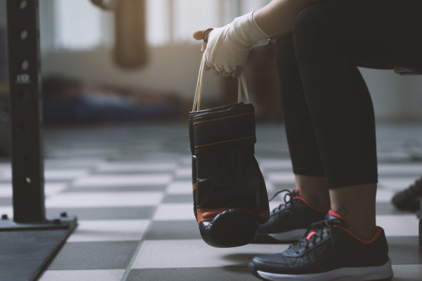 戴拳击手套的女人坐在长凳上图片下载