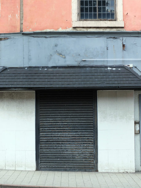 英国利兹废弃的商业地产，黑色百叶窗紧闭，油漆剥落图片下载