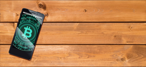 加密货币概念 [显示比特币的智能手机在木板上]图片下载