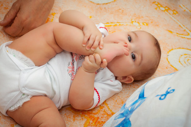 可爱的婴儿，美丽的蓝眼睛躺在白色的床上图片下载