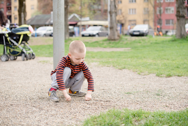 小男孩在鹅卵石里玩图片下载