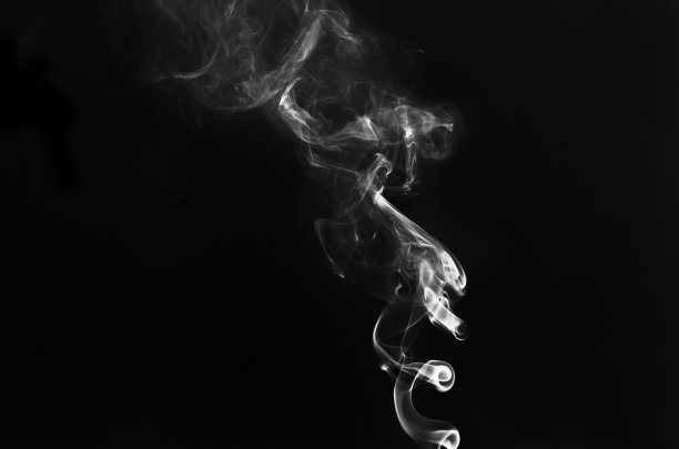 白色烟雾在黑色背景上的抽象碎片运动。图片下载