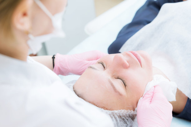 美容室清洁过程的特写。用泡沫清洁皮肤。美丽的女孩在美容院做面部清洁。美容师的工作素材图片