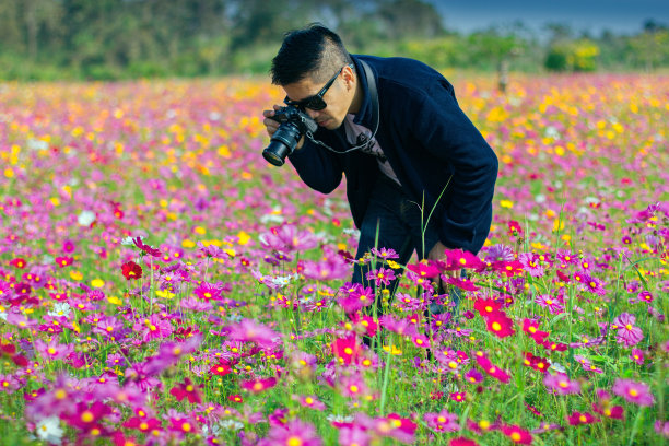 一名男子摄影师正在拍照。靠近宇宙花园图片下载