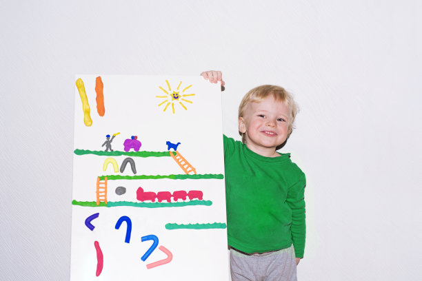 小男孩微笑着玩粘土板。图片下载