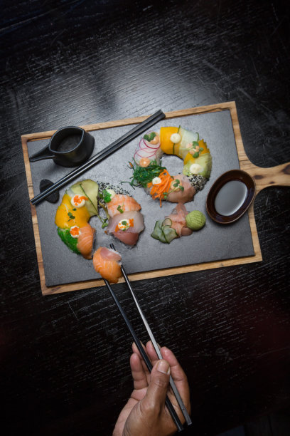寿司套餐用手拿筷子在餐厅吃寿司图片下载