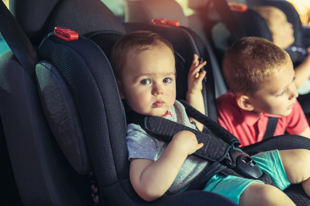 三个孩子坐在汽车安全座椅上图片下载