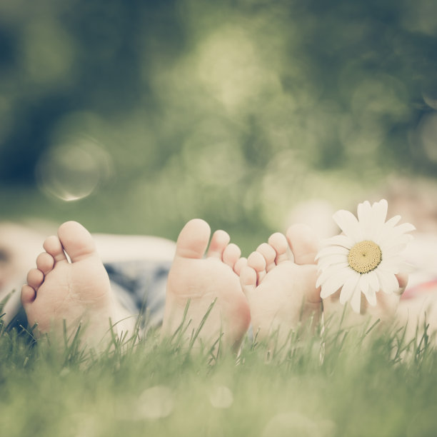 一家人躺在绿草地上。孩子们在户外的春天公园里玩耍。复古的图片图片下载