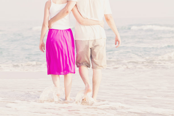 夏日情侣在海滩上的日落手拉手图片下载