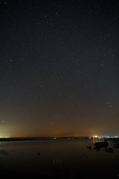 夜空中明亮的星星映衬着平静的湖面。图片下载