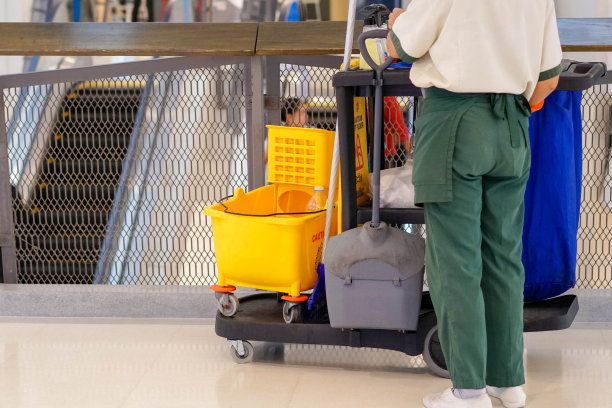 在大楼里拿着清洁用品的女人。图片下载