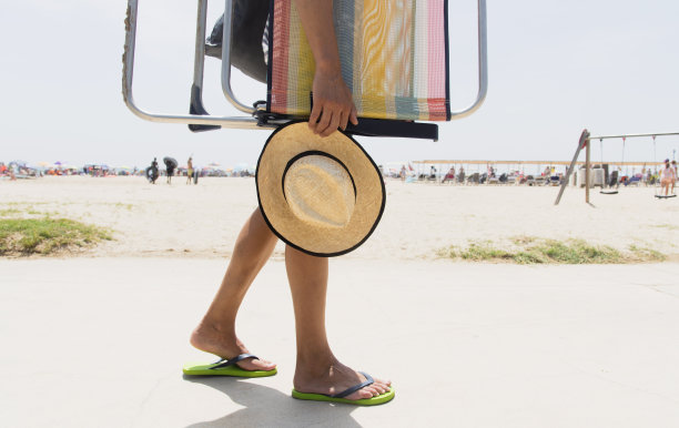 一个背着沙滩椅的年轻人图片下载