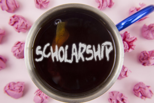 显示奖学金的概念性手写。商业照片展示资助或资助教育的学术研究写在纸球杯茶在普通的背景。图片下载