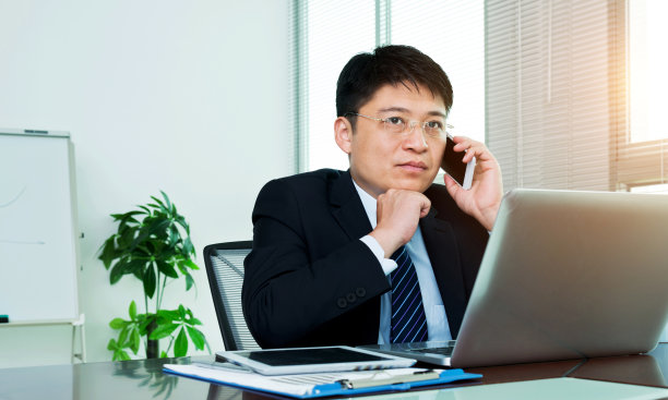 在办公室用手机交谈的商人素材图片