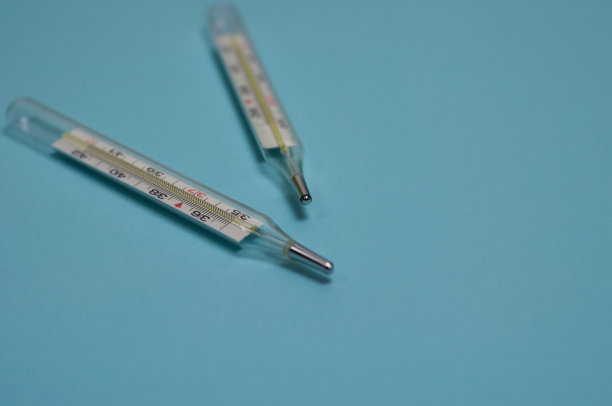 两个玻璃水银温度计在蓝色背景和复制空间图片下载