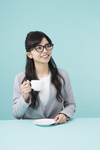 一个穿着西装拿着白色杯子的女人图片下载