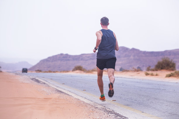 男子在约旦瓦迪拉姆沙漠跑步图片下载